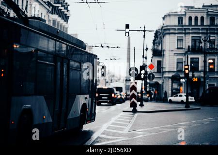 Le bus traverse une ville européenne pluvieuse à la tombée de la nuit. Circulation en ville. En bus. Transports en commun. Banque D'Images