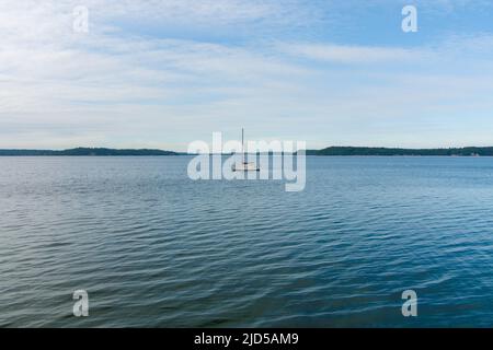 Un seul voilier sur le Puget Sound à Nisqually Reach dans l'État de Washington Banque D'Images