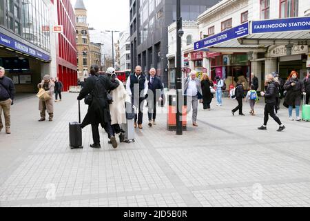 Les gens piétons et couple avec des bagages marchant dans Cowcross Street à l'extérieur de la gare Farringdon à Clerkenwell Londres Angleterre KATHY DEWITT Royaume-Uni Banque D'Images