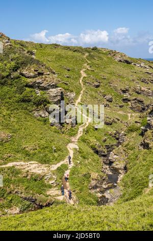 Randonneurs grimpant dans la section de Rocky Valley du South West Coast Path Tintagel Cornouailles Angleterre Royaume-Uni Banque D'Images