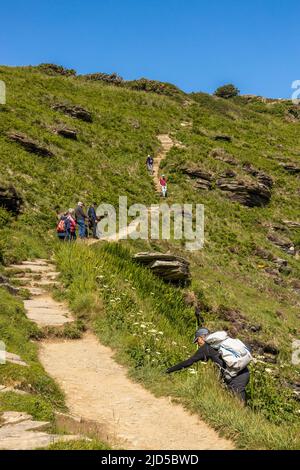 Randonneurs grimpant dans la section de Rocky Valley du South West Coast Path Tintagel Cornouailles Angleterre Royaume-Uni Banque D'Images