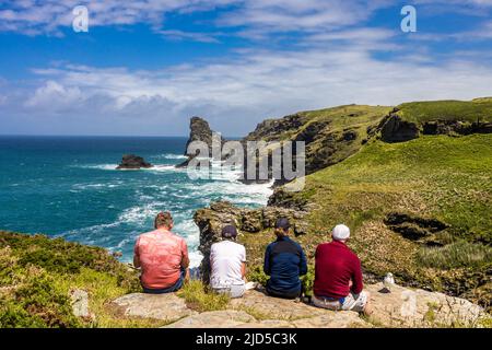 Deux couples bénéficiant d'un arrêt de repos de randonnée et de la magnifique vue sur la mer depuis le sentier de la côte sud-ouest près de Trewethett Farm Tintagel Cornouailles Angleterre Banque D'Images