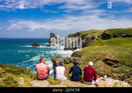 Deux couples bénéficiant d'un arrêt de repos de randonnée et de la magnifique vue sur la mer depuis le sentier de la côte sud-ouest près de Trewethett Farm Tintagel Cornouailles Angleterre Banque D'Images