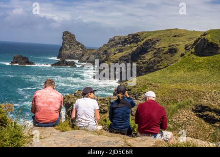 Deux couples bénéficiant d'un arrêt de repos de randonnée et de la magnifique vue sur la mer depuis le sentier de la côte sud-ouest près de Trewethett Farm Tintagel Cornouailles Angleterre Banque D'Images