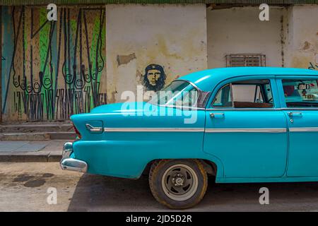 Une voiture bleue d'époque avec une fresque du Che Guevara en arrière-plan dans la vieille Havane, Cuba Banque D'Images