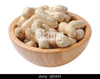 Tas d'arachides non décortiquées dans un bol rond en bois, isolé sur fond blanc Banque D'Images