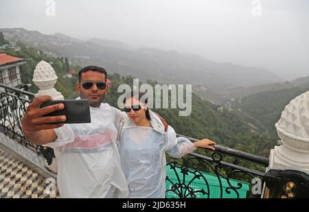 Mussoorie, Uttarakhand, Inde, 18 juin 2022: Un couple indien prend le selfie comme ils appréciant la première pluie de mousson à Mussoorie. Les touristes de tout le pays viennent ici pour célébrer le week-end en été. Crédit : Sumit Saraswat/Alay Live News Banque D'Images