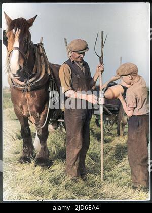 Après un labour matinal difficile, deux ouvriers agricoles de Kentish prennent une pause bien méritée et se versent une tasse de cidre dans une fiole de poterie. Version colorisée de : 10108974 Date: Vers 1950 Banque D'Images