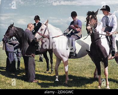 Les concurrents juniors reçoivent leurs cartes de récompense de l'un des juges lors d'un spectacle équestre à Heswall, Cheshire, en Angleterre. Version colorisée de : 10185169 Date: 1950s Banque D'Images