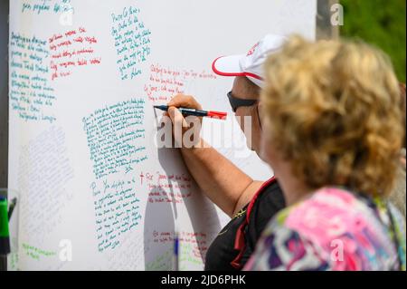 Les gens écrivent leurs prières sur un long rouleau de feuilles pendant Mladifest 2021 – le festival de la jeunesse – à Medjugorje. Banque D'Images