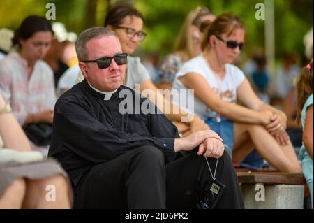 Un prêtre, parmi d'autres pèlerins, à l'écoute d'une catéchèse pendant Mladifest 2021 - le festival de la jeunesse - à Medjugorje. Banque D'Images