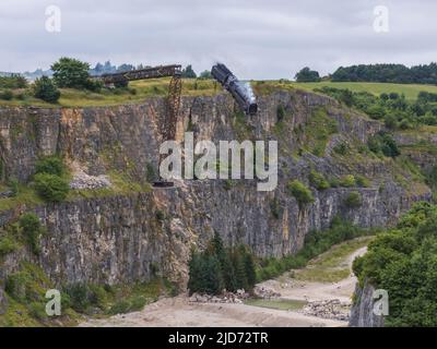 ***Vidéo disponible*** Mission: Impossible 7 scène d'accident de train de locomotive à Stoney Middleton, Derbyshire. La réplique du train à vapeur du British Railway Britannia est chassés de la falaise pour la scène finale de l'accident dans le dernier film à succès de Tom Cruise. La locomotive vole dans les airs dans un style spectaculaire avant de s'écraser dans la carrière ci-dessous. La scène a été filmée par deux hélicoptères et de nombreuses caméras à distance. Tom Cruise est arrivé juste avant la scène de l'accident final dans son hélicoptère personnel, il a voyagé autour du film avant d'atterrir dans les champs près de la voie ferrée au-dessus de la carrière. Le TR de vapeur Banque D'Images