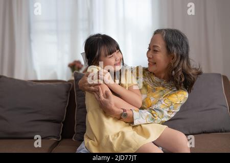 Une belle fille asiatique et sa grand-mère apprécient le matin ensoleillé. Bon séjour à la maison. Banque D'Images