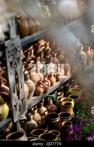 Beaucoup de cruches et vases en argile uniques et colorés faits à la main de formes diverses sur l'étagère dans le marché local Banque D'Images