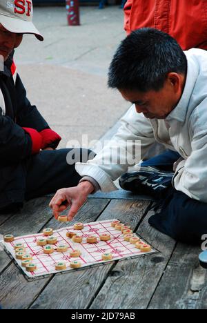 Deux hommes adultes participent à un match de xiangqi dans le quartier chinois de San Francisco Banque D'Images