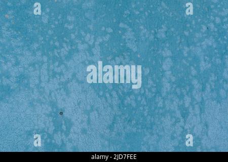 Texture de la surface peinte en bleu usée du panneau de particules. Surface décolorée avec de nombreuses taches lumineuses, craquelée et partiellement décollée, arrière-plan abstrait. Banque D'Images