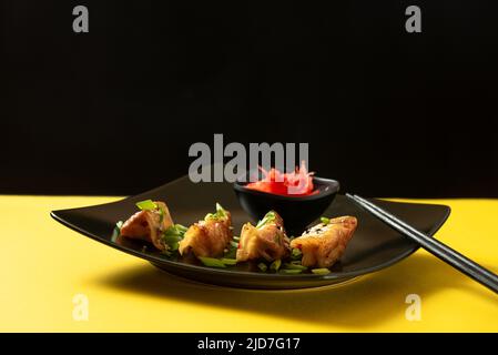 Beignets japonais originaux Gyoza au poulet et aux légumes. Vue avant. Cuisine asiatique classique. Boulettes de gyoza frites sur fond jaune Banque D'Images