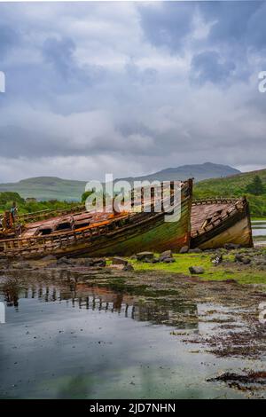 Salen, île de Mull, Écosse - abandon de bateaux de pêche en bois abandonnés sur la plage qui se décompose et pourriture lentement Banque D'Images