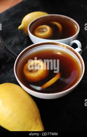 tasse en porcelaine blanche avec café chaud noir et une tranche de citron Banque D'Images