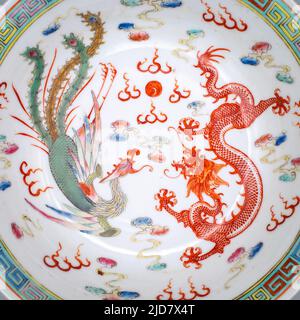 Antique Chinese famille Rose porcelaine bol avec Dragon et Phoenix Fenghuang Décoration. Guangxu ou République. Marqué Qianlong Banque D'Images