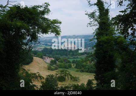 Vue sur la vallée et le château appelé Castello di Torrechiara à travers le feuillage luxuriant dans la province de Parme, Italie. Paysage italien typique avec champ de récolte Banque D'Images