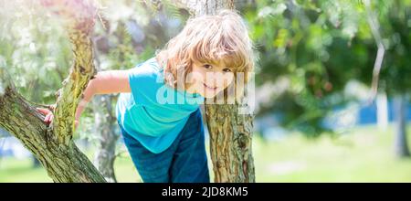 Grimper les arbres est toujours amusant. Arbre de montée enfant de garçon actif. Amusement d'enfance. En été. Affiche horizontale. En-tête de bannière Web, espace de copie Banque D'Images