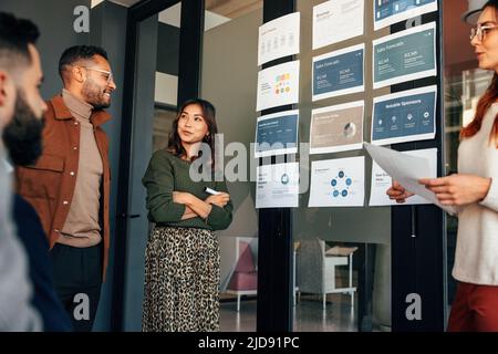 Équipe d'hommes d'affaires analysant certains rapports dans une salle de réunion. Groupe d'hommes d'affaires multiculturels ayant une réunion dans un bureau moderne. Entrée diversifiée Banque D'Images