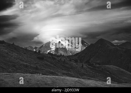 Lumière du soleil sur le groupe de montagne Marmolada. Des nuages en mouvement. Ciel spectaculaire. Les Dolomites. Alpes italiennes. Europe. Noir blanc paysage. Banque D'Images