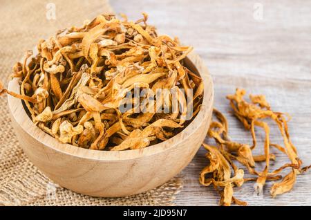 Le cordyceps militaris séché fleur de champignon sur fond de bois. Banque D'Images