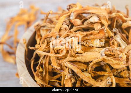 Le cordyceps militaris séché fleur de champignon sur fond de bois. Banque D'Images