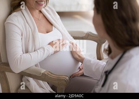 Médecin obstétricien touchant le ventre de la femme enceinte, gros plan grené Banque D'Images