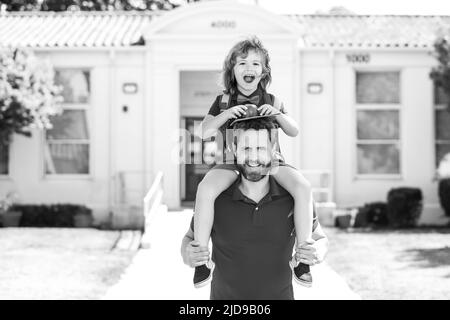 L'homme et l'enfant excités surpris de son porcgyback près de l'école. Le père soutient et motive son fils. Enfant allant à l'école primaire. Banque D'Images