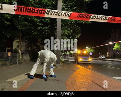 Hanovre, Allemagne. 18th juin 2022. Un membre de l'équipe de médecine légale obtient des preuves sur le sentier de la Hildesheimerstraße près d'un arrêt de feu de chemin de fer. Un homme de 25 ans a été grièvement blessé lors d'une altercation avec un adolescent. Selon la police, l'homme de 16 ans a tiré un couteau et attaqué l'homme plus âgé. La victime a été opérée pendant la nuit, a déclaré un porte-parole de la police le 19.06.2022. Credit: Frank Tunnat/dpa/Alay Live News Banque D'Images