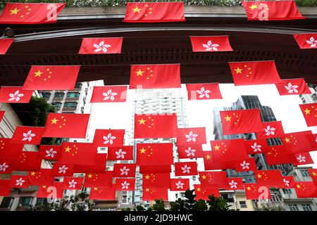 Hong Kong, Chine. 19th juin 2022. Les drapeaux nationaux de la Chine et les drapeaux de la région administrative spéciale de Hong Kong (HKSAR) sont suspendus au-dessus d'une rue à Hong Kong, dans le sud de la Chine, au 19 juin 2022. Cette année marque le 25th anniversaire du retour de Hong Kong à la mère patrie. Credit: Wu Xiaochu/Xinhua/Alay Live News Banque D'Images