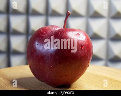 Une grande pomme rouge. Gouttelettes d'eau sur un pelage de pomme. Pomme de la variété Red Chief. Banque D'Images