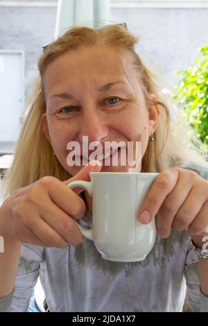 Femme blonde plus âgée d'Europe de l'est qui boit du thé Banque D'Images