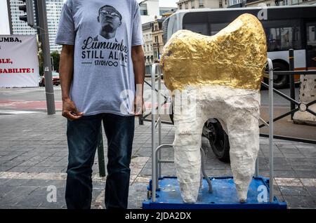 Un homme portant un T-shirt qui lit ' Lumumba alive encore pose à côté d'un modèle d'une dent. Amené au pays par un policier belge, la dent de Lumumbas était le seul reste de son corps après l'assassinat du politicien en 1961. Le gouvernement belge retournera cette semaine une dent de Patrice Lumumba à sa famille. La diaspora congolaise rend hommage à Patrice Emery Lumumba, pendant la période la plus prospère à Bruxelles, Belgique le 19/06/2022 Lumumba était un homme politique congolais et un dirigeant indépendantiste qui a été le premier Premier ministre de la République démocratique du Congo. Après son assassinat, Banque D'Images