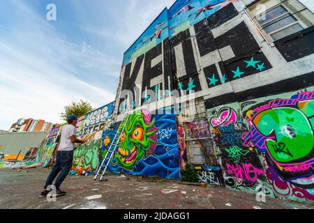 M. KEOS, artiste de rue appliquant de la peinture sur le mur du parc de skate de Jamaica Street, Baltic Triangle, Liverpool, Royaume-Uni Banque D'Images