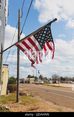 Drapeau américain flatté volant sur un bâtiment de main Street. Banque D'Images
