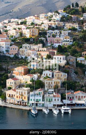 Vue d'ensemble des bâtiments et des voiliers de couleur pastel amarrés le long de la digue à Gialos Harbour, île Symi (Simi); Dodécanèse Island Group, Grèce Banque D'Images