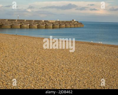 Vue de Brighton Beach et des défenses maritimes vers la marina au coucher du soleil ; Brighton, East Sussex, Angleterre Banque D'Images