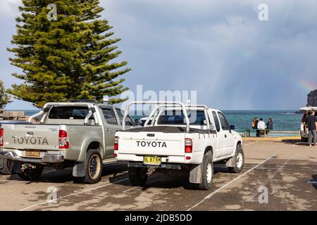 Véhicules utilitaires Toyota Hilux ute garés au parc de véhicules Avalon Beach, modèle 2013 à gauche et 1999 véhicules blancs, Sydney, Nouvelle-Galles du Sud, Australie Banque D'Images