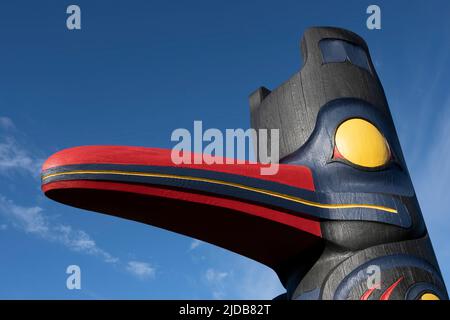 Totem pôle, un type d'art de la côte nord-ouest, contre un ciel bleu; Tofino, Colombie-Britannique, Canada Banque D'Images