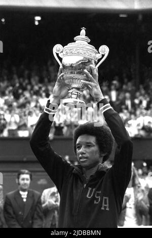 Photo du dossier en date du 05-07-1975 d'Arthur Ashe détient triomphalement le trophée des célibataires hommes au-dessus de sa tête à Wimbledon, après avoir battu Jimmy Connors dans la finale sur Center court. L’américain Arthur Ashe a choqué le compatriote Jimmy Connors lors de la finale masculine des singles en 1975 pour devenir le premier, et jusqu’à présent le seul, noir à remporter un titre de singles de Wimbledon. Date de publication : lundi 20 juin 2022. Banque D'Images