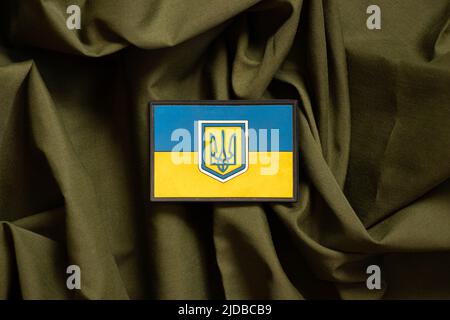 Patch sur le drapeau militaire uniforme de l'Ukraine jaune-bleu se trouve sur un fond de camouflage vert, le fond militaire, l'armée de l'Ukraine Banque D'Images