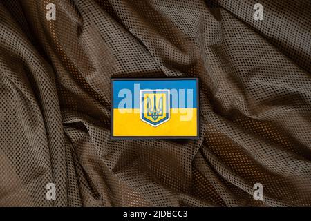 Patch sur le drapeau militaire uniforme de l'Ukraine jaune-bleu se trouve sur un fond de camouflage vert, le fond militaire, l'armée de l'Ukraine Banque D'Images