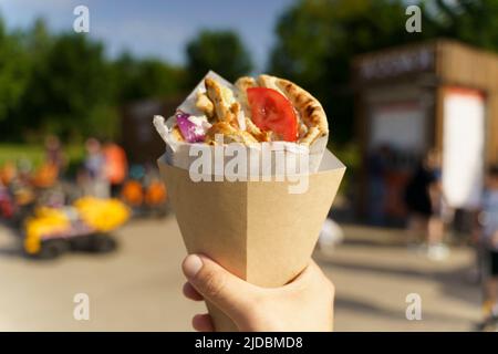 Cuisine grecque de rue gyros à la main. Cuisine grecque et méditerranéenne avec viande en pita. Photo de haute qualité Banque D'Images