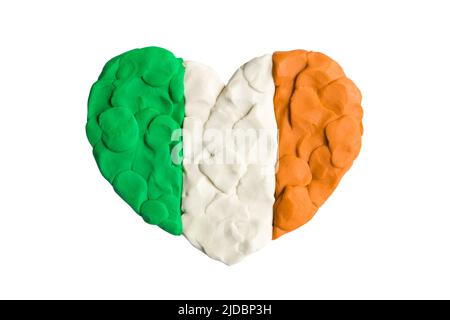 Drapeau vert, blanc et rouge orange de l'Irlande, drapeau irlandais. Forme du coeur de l'argile à modeler tricolore de plasticité de drapeau isolée sur fond blanc. Plastici Banque D'Images