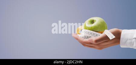 Nutritionniste tenant un mètre ruban et un concept de pomme, de forme physique et de régime alimentaire Banque D'Images