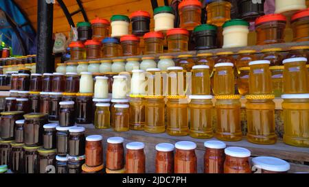 Les pots de miel et de confiture sont des colonnes et des rangées dans la fenêtre. Souvenirs pour les touristes en Géorgie, miel jaune et rouge, confiture de cônes. Comestible frais naturel SW Banque D'Images